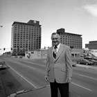 Walter "Wally" Hickel stands in front of his Hotel Captain Cook in May 1974, before the third tower was built where the Bering Sea Original store stood.  