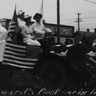 Another view of Joseph "Joe" Spenard driving in a parade, this time touting the American Red Cross, possibly during World War I in 1917 or 1918.  Whether he had the first automobile or truck in Anchorage is less certain.